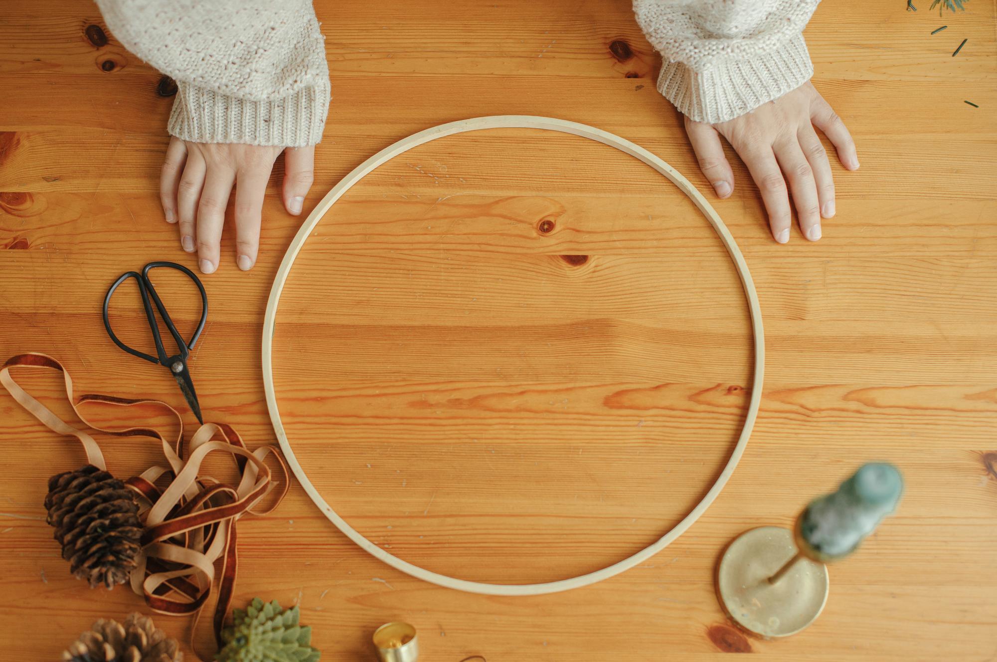 Artisan hands stitching a hoop in natural light